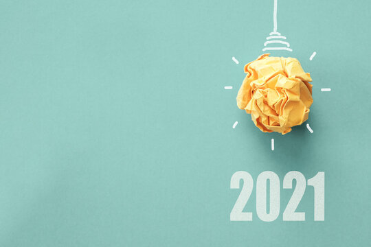2021 Yellow paper light bulb on blue background, innovative business vision and resolution concept
