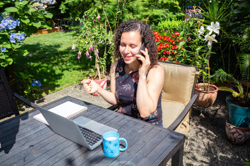 Young Caucasian Woman Working on a Laptop from Home in a Garden. Taken in Surrey, Vancouver, British Columbia, Canada.
