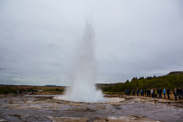 The Strokkur Geyser in Iceland, on a cloudy day.