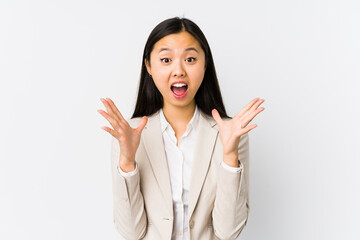 Young chinese business woman isolated celebrating a victory or success, he is surprised and shocked.