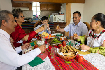 A family toasting with tequila shots during a traditional Mexican dinner