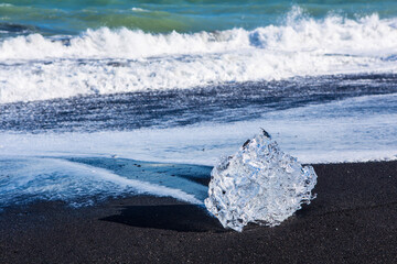 The ice rocks on the black beach, known as diamond beach, at the south coast of Iceland, summer time, on a sunny day.