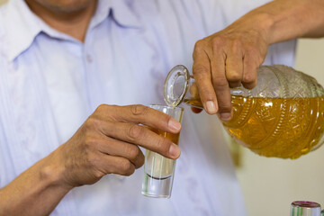 Detail of a Mexican man preparing a shot of tequila