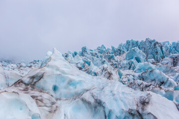 Close view of the blue glaciers in Vatnajokull National Park, in Iceland, on a cloudy day.