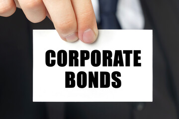 Businessman shows a card with the text - CORPORATE BONDS