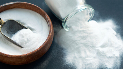Glass bowl of baking soda. Spoonful of bicarbonate.