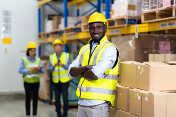 middle aged African American warehouse worker preparing a shipment in large warehouse distribution centre