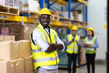 middle aged African American warehouse worker preparing a shipment in large warehouse distribution centre