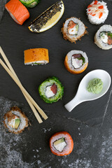 Sushi set on gray concrete background. Rainbow sushi roll, uramaki, hosomaki and nigiri.