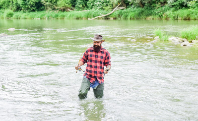 be successful. hobby and sport activity. bearded fisher in water. fisherman show fishing technique use rod. mature man fly fishing. man catching fish. summer weekend. Successful fly fishing