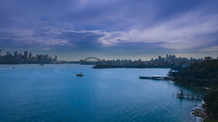 Obraz premium Panoramic drone aerial view over Sydney harbour on a cloudy sunset showing the nice colours of the CBD aparments and officer towers