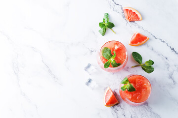 Ruby red grapefruit cocktail with mint leaves in glasses