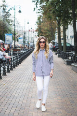 Fototapeta premium beautiful stylish young girl posing for a photographer on the street