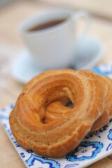 Morning. Espresso coffee in a porcelain cup on a saucer. Cake Ring with cream on a square plate with oriental ornaments