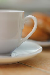 Morning. Espresso coffee in a porcelain cup on a saucer. Cake Ring with cream on a square plate with oriental ornaments