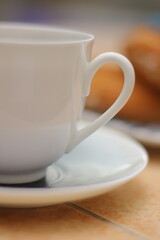 Morning. Espresso coffee in a porcelain cup on a saucer. Cake Ring with cream on a square plate with oriental ornaments
