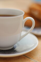 Morning. Espresso coffee in a porcelain cup on a saucer. Cake Ring with cream on a square plate with oriental ornaments