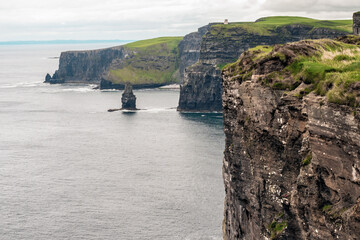 Cliff of Moher, county Clare, Ireland. Famous Irish tourist destination. Calm Atlantic ocean, green...