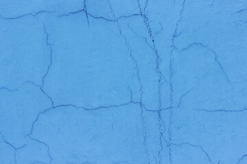Cracks on the blue wall. Blue plaster background