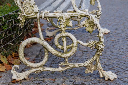 beautiful white wrought iron bench legs on a dark background close up