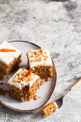 pieces of carrot cake with walnuts with icing cream on a light background. tinting. selective focus