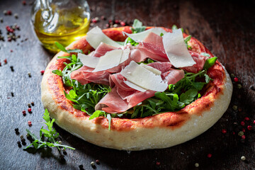 Delicious pizza Parma with prosciutto, arugula and parmesan