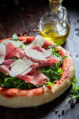 Rustic pizza Parma with parmesan cheese and parma ham
