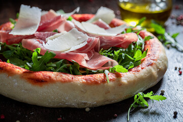 Fresh pizza Parma with prosciutto, arugula and parmesan
