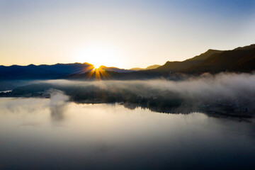 Lovely autumnal landscape with fog over the lake.