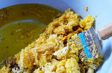 Drop of bee honey drip from hexagonal honeycombs