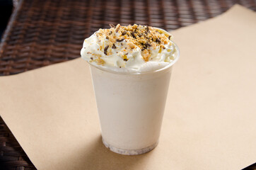 white milkshake with ice cream garnished with chocolate and nut crumbs