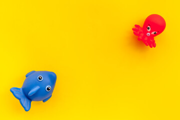 The concept of children’s bath toys. Yellow background top view copyspace