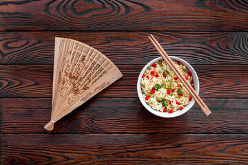 Instant noodle with pepper,peas, chopstick and greens. Dark wooden background top view copy space