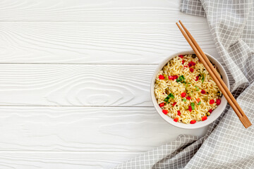 Instant noodle with pepper,peas and greens. White wooden background top view copy space