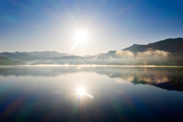 Fototapeta na wymiar Lovely autumnal landscape with fog over the lake.