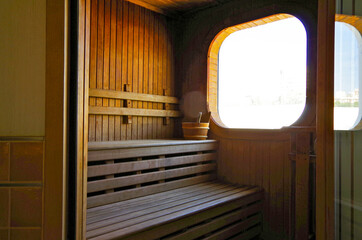 Finnish or dry sauna with oceanview or view of the sea inside male locker room of spa or wellness...