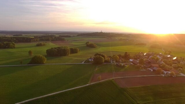 Drone is flying above bavarian fields during sunset