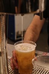 Fototapeta na wymiar Male hand tapping beer during an evening event