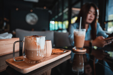 Transparent coffee cup Hot cappuccino on the table in a coffee shop with people.