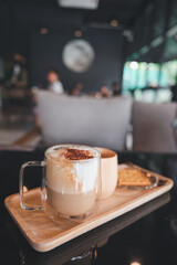Transparent coffee cup Hot cappuccino on the table in a coffee shop with people.