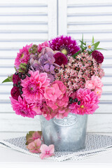 Blumenstrauß mit pink Hortensienblüten, Dahlien und Fettehenne im vintage Topf