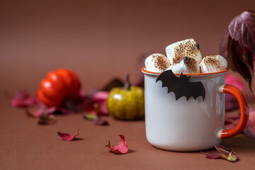 Cup of hot chocolate with marshmallow. Tasty Halloween food. Concept of cozy winter home environment. Autumn background.