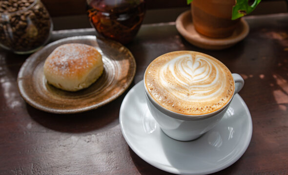 Coffee latte with bread on a wooden table. Soft focus image.