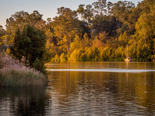 Beautiful River Scene with Boat and Reflections in Golden Afternoon Light