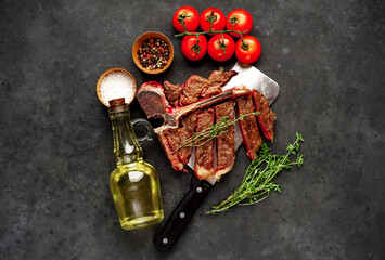 grill t-bone steak with ingredients on a meat knife on stone background