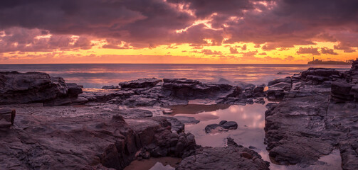 Beautiful Panoramic Golden Seaside Sunrise with Rockpool Reflections