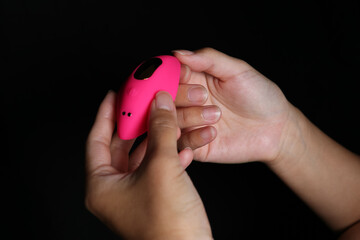 Woman holding her brand new Pink remote controlled silicon vibrator.