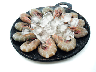 Top view of fresh prawns on a black plate with ice, selective focus.white background.