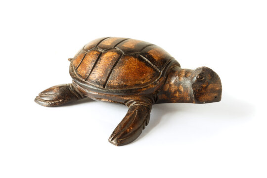 Wooden figurine of a sea turtle isolated on a white background.