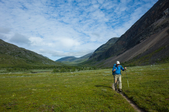 Hiking in Swedish Lapland. Man trekking alone in Vistasvagge valley in northern Sweden. Arctic mountain nature of Scandinavia in summer day